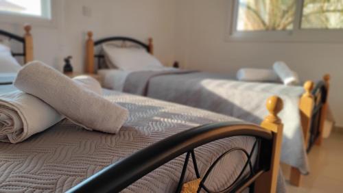 a room with three beds with towels on top at Lovely holiday home,Kapparis,2 swimming pools,Wifi in Paralimni