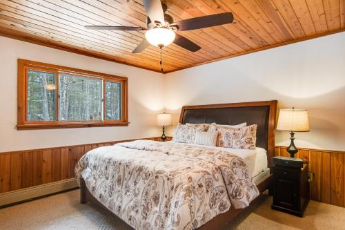 a bedroom with a bed and a ceiling fan at SILK Cabin in Manitowish Waters