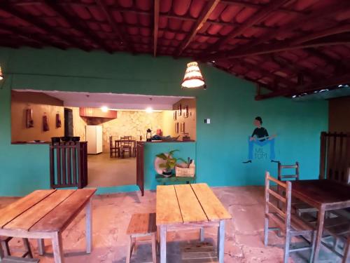 a dining room with wooden tables and a green wall at BITUCA HOSTEL CAFÉ in Milho Verde