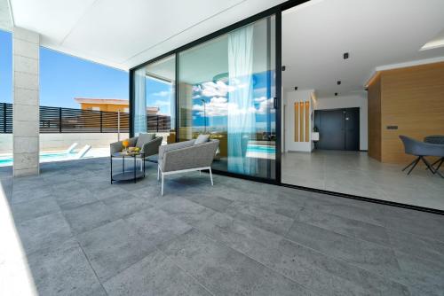 a living room with glass walls and a couch at Villa Sant Meloneras in Meloneras