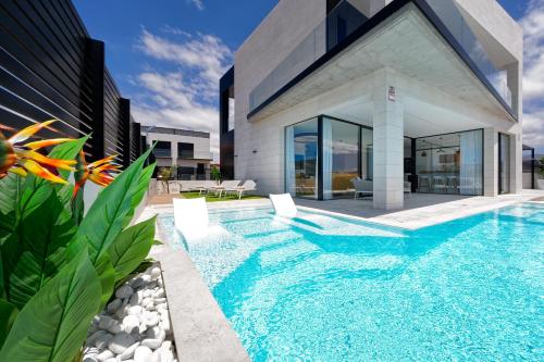 a swimming pool in front of a house at Villa Sant Meloneras in Meloneras