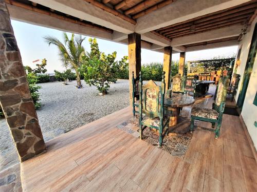 porche con mesa y sillas en la playa en Apartamento frente al mar con jardín privado, en Puebloviejo