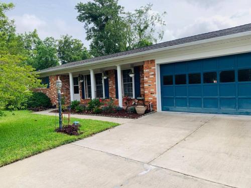 a brick house with a blue garage door at Cush Jax Baymeadows Ranch, Close to Everything! in Jacksonville