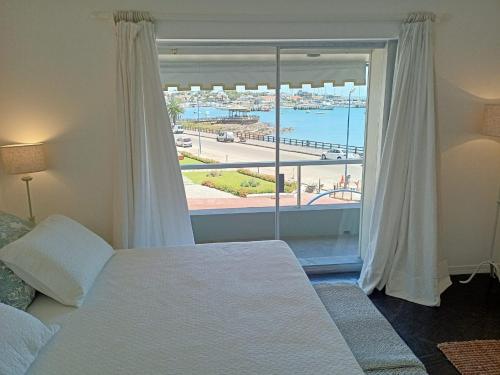 a bedroom with a large window with a view of the ocean at El Remanso - Suite 104 in Punta del Este