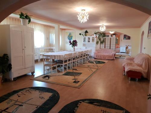 a dining room with a table and a room with rugs at Antal Apartmans Lunca de Sus Kulcsosház Gyimesfelsőlok in Lunca de Sus