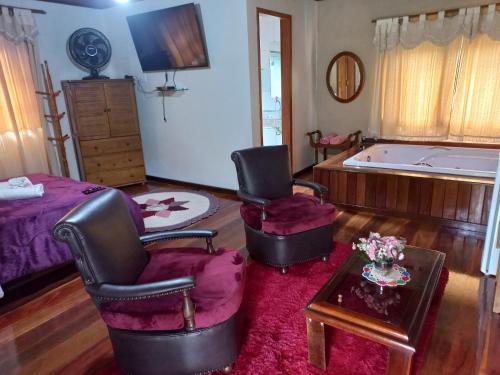 a living room with two chairs and a tub at Sítio Recanto do Araçá in Visconde De Maua