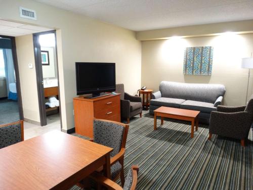 a living room with a couch and a tv at Best Western Warren Hotel in Warren