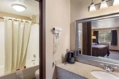 a bathroom with a sink and a mirror at SureStay Hotel by Best Western Summersville in Summersville