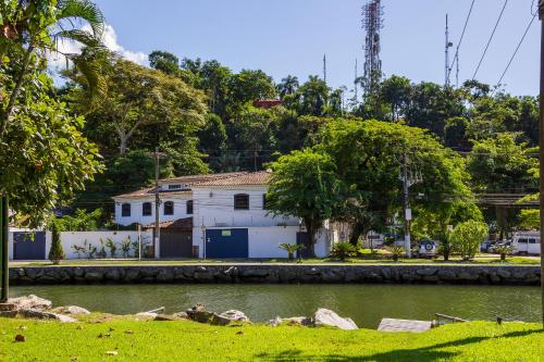 a white building next to a body of water at Pousada Casa dos Autores in Paraty