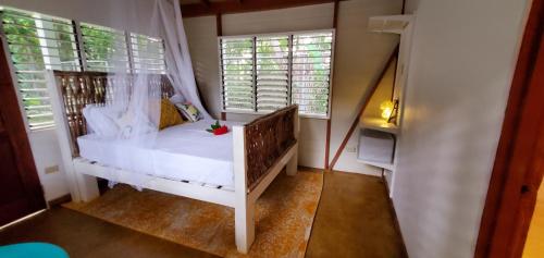 a small bedroom with a bed and two windows at Bak A Yaad in Negril