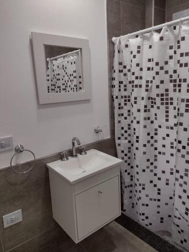 a bathroom with a sink and a shower curtain at DTo CÉNTRICO LOBOS PB in Lobos