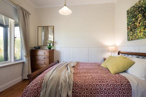 a bedroom with a bed and a mirror and a window at Koovelly Spa in Hepburn