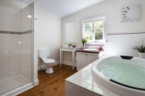 a bathroom with a tub and a shower and a toilet at Koovelly Spa in Hepburn