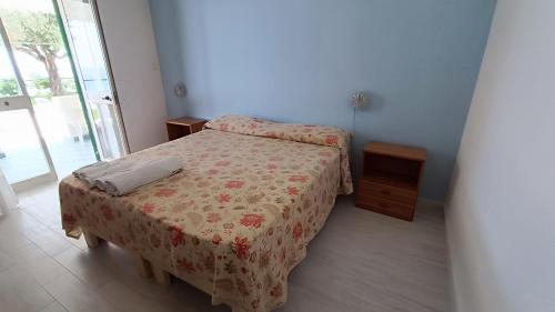 a small bedroom with a bed with a flowered bedspread at La Dea del Mare in Ischia