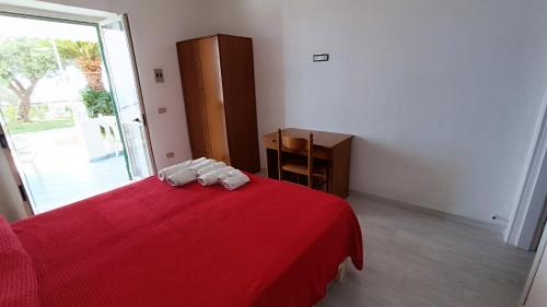 a bedroom with a red bed with a red blanket at La Dea del Mare in Ischia