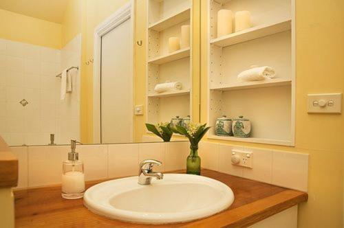 a bathroom with a sink and a mirror at Quince Cottage - scenic escape with spa in Daylesford