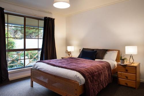 - une chambre avec un grand lit et une fenêtre dans l'établissement Springview Cottage, à Hepburn Springs