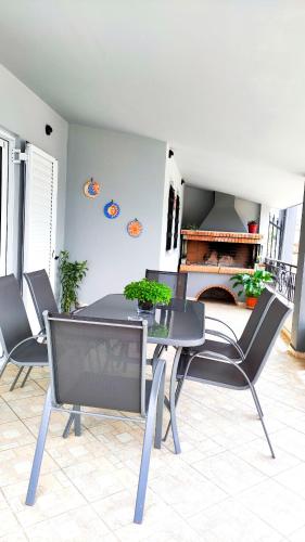 a dining room with a table and chairs and a fireplace at Anastasiou Home in central crossroad in Parga