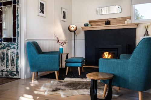 a living room with two chairs and a fireplace at Table Hill Cottage - dog friendly retreat in Daylesford
