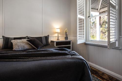 a bedroom with a bed and a window at Table Hill Cottage in Daylesford