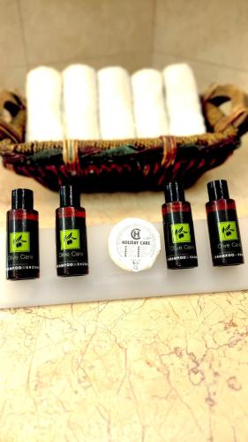 four bottles of essential oils on a counter with a basket of towels at Anastasiou Home in central crossroad in Parga