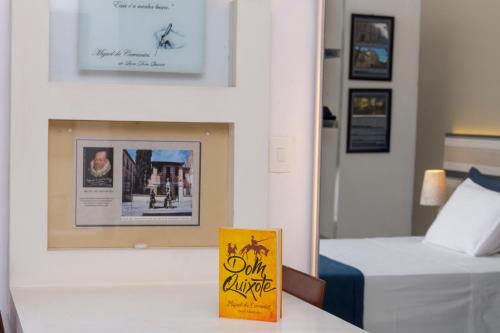 a hotel room with a bed and a book on a table at Pousada Casa dos Autores in Paraty
