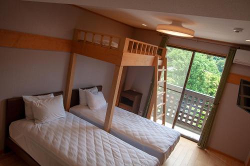 霧島市にある霧島みやまホテルのバルコニー付きのドミトリールームの二段ベッド2台分です。