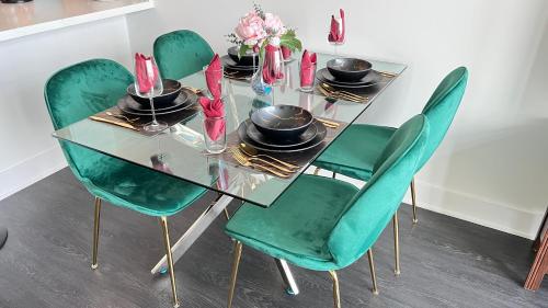 a glass table with green chairs and hats on it at Sky-Rise Apartments in Los Angeles