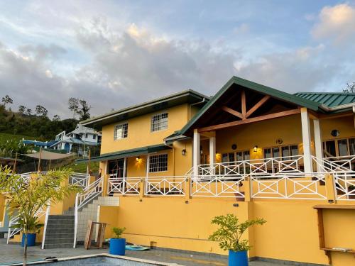 a yellow house with a balcony at The Victory Villa in Parrot Hall