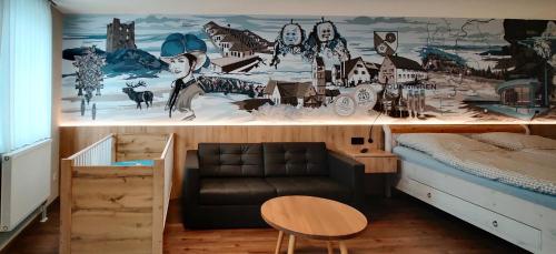 a room with a couch and a wall with a mural at Braustube Wehle in Dunningen