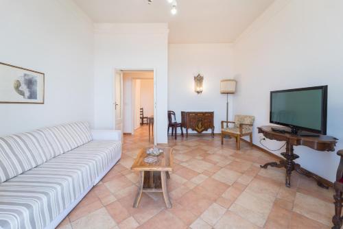 een woonkamer met een bank en een flatscreen-tv bij Seaview Alghero Apt in Alghero