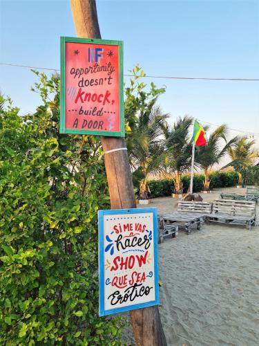 two signs on a pole on a beach with a beach at SUITE CON TERRAZA PANORAMICA in Puebloviejo