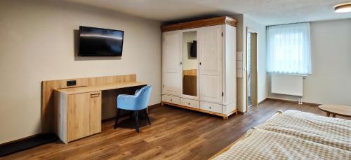 a bedroom with a bed and a desk and a tv at Braustube Wehle in Dunningen