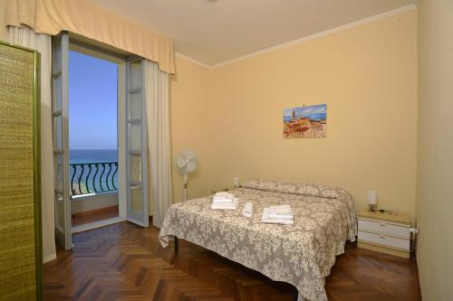 een slaapkamer met een bed en uitzicht op de oceaan bij Casa Alice in Alghero