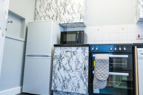 eine Küche mit einem Herd und 2 Kühlschränken in der Unterkunft Vanville Homes in Manchester