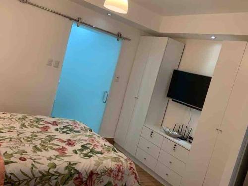 a bedroom with a bed and a flat screen tv at Espectacular Apartamento En Tanama Cap Cana in Punta Cana