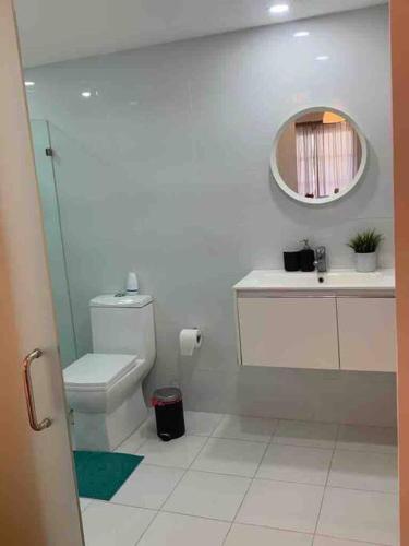 a bathroom with a toilet and a sink and a mirror at Espectacular Apartamento En Tanama Cap Cana in Punta Cana