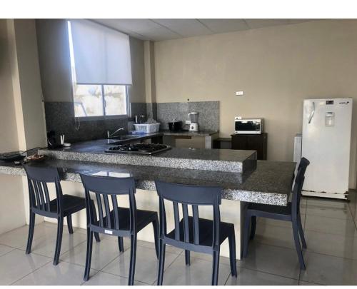 薩利納斯的住宿－KsaMarita，厨房配有带椅子的柜台和冰箱。