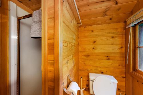 a bathroom with wooden walls and a toilet at Cabin in the Pines in Joseph