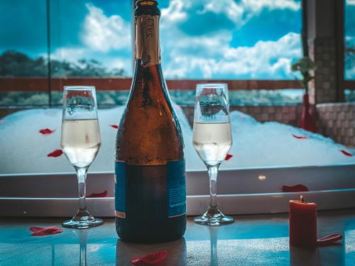 a bottle of champagne and two glasses on a table at Pousada Toca da Onça in Gonçalves
