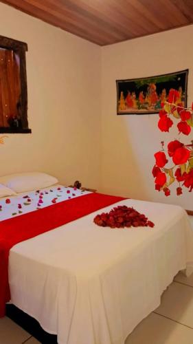a bedroom with two beds with red flowers on it at Topo do Cipó Ecopousada Vegana in Serra do Cipo