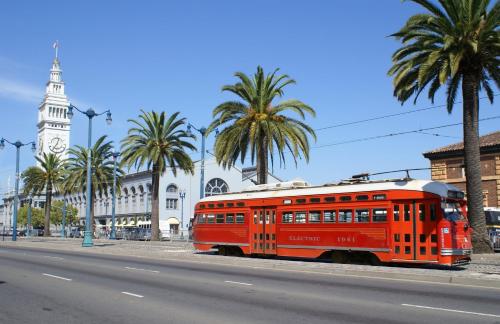 an orange trolley on the side of a street with palm trees at Kimpton Hotel Enso by IHG in San Francisco