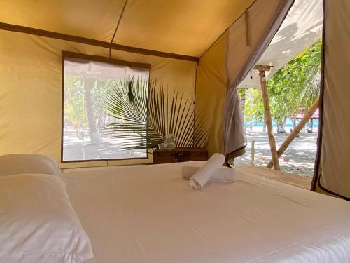 sypialnia z białym łóżkiem i oknem w obiekcie Manoush Beach w mieście Buritaca