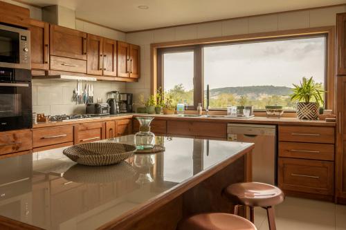 a kitchen with a large window and a counter with stools at Cabañas Arrayanes de Huillinco en Chiloé in Chonchi