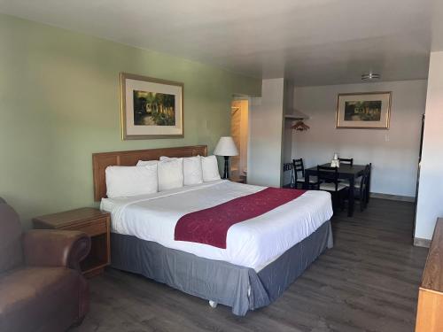Habitación de hotel con cama grande y escritorio. en Adobe Inn Durango, en Durango
