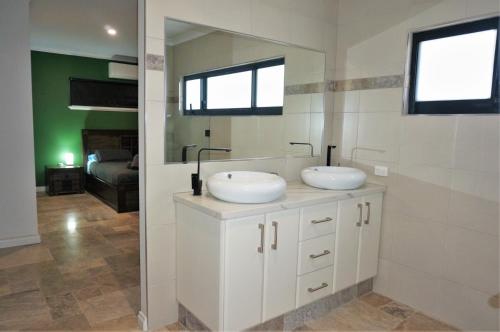 ein Badezimmer mit zwei Waschbecken und einem Spiegel in der Unterkunft 27 Corella Court in Exmouth