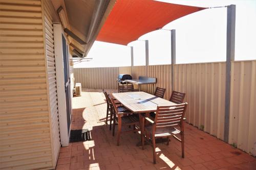 a patio with a table and chairs on a balcony at Osprey Holiday Village Unit 104 in Exmouth