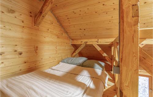 1 dormitorio en una cabaña de madera con 1 cama. en Awesome Home In Mokronog With Sauna, 2 Bedrooms And Wifi, en Mokronog
