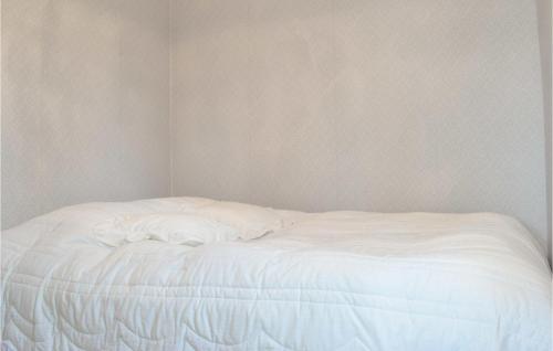 an unmade white bed in a corner of a room at 2 Bedroom Stunning Home In Rockneby in Rockneby