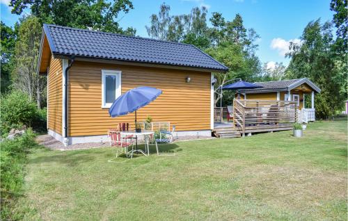 a small house with a table and a blue umbrella at 2 Bedroom Stunning Home In Rockneby in Rockneby